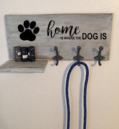 a dog leash is hanging on the wall next to a sign that says home is where the dog is