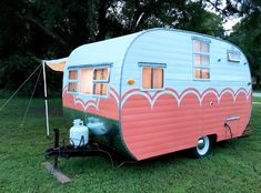 an old trailer is parked in the grass