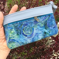 "Wallet, Clutch,or Phone case in Sky Blue Italian Leather paired with a pretty Boho Paisley Batik.This bag can carry your essentials and be your only bag-or use it in your big purse as I do for a wallet. Front zip works for change and top zip opens main section which fits dollar bills. There's also a small inside pocket that holds credit cards. Nice to carry jewelry when traveling. Or for your 7\" Knitting Needles and Crochet Hooks. 7 1/2\" wide 4 3/4\"deep PLEASE NOTE BATIK VARIES SLIGHTLY Matc Blue Bohemian Clutch For Daily Use, Bohemian Blue Clutch For Daily Use, Blue Pouch Wallet For Personal Use, Blue Pouch Wallet, Blue Bohemian Clutch For Everyday Use, Blue Bohemian Rectangular Pouch, Handmade Blue Wallet For Everyday Use, Handmade Blue Coin Purse For Travel, Blue Pouch Wallet With Zipper