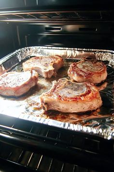 some meat is cooking in an oven on tin foil