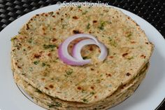 three tortillas on a white plate with onions