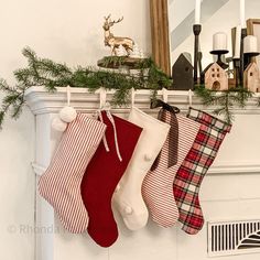 three stockings hanging from a mantel decorated with evergreen branches and red plaid stocking