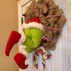 a wreath is hanging on the front door with christmas stockings and santa's hats