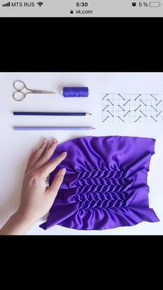 someone is making something with purple material and scissors