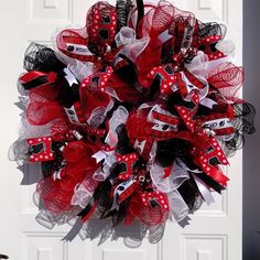 a red, black and white mesh wreath on a front door with the word love written across it