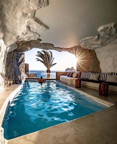 an indoor swimming pool surrounded by rock formations