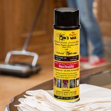 a can of insect wax sitting on top of a table next to a pile of white cloth