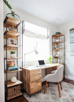 a desk with a laptop computer on top of it next to a chair and window