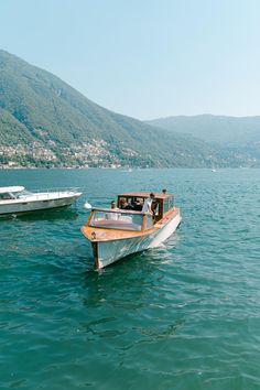 two boats in the water with mountains in the background