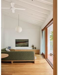 a living room filled with furniture and a flat screen tv on top of a wooden floor