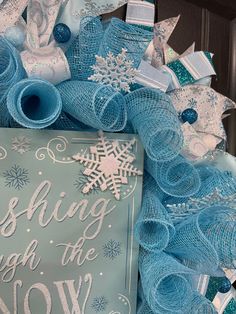 a blue wreath with white snowflakes on it and a sign that says wishing through the snow