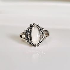 Colors Vary Due To The Nature Of The Stone Design: Vintage, Art Deco, Beaded Top Of Ring Height: 12.8mm X 11.5mm Band Width: 1.9mm Center Stone Size: 9.3mm X 4.6mm Stone Shape: Oval Genuine Mother Of Pearl Total Number Of Stones: 1 Metal: 925 Sterling Silver Finish: Oxidized 925 Stamped K E E P I N T O U Ch Https://Instagram.Com/Emmaverajewelry Https://Www.Facebook.Com/Emmaveradesign Thank You For Visiting My Shop White Oval Pearl Ring Gift, White Moonstone Crystal Ring For Anniversary, White Oval Pearl Ring As A Gift, White Round Crystal Ring Gift, Dainty White Pearl Ring With Gemstone, White Moonstone Ring For Promise, Dainty White Crystal Ring, Classic White Opal Ring For Gift, White Open Moonstone Ring For Anniversary