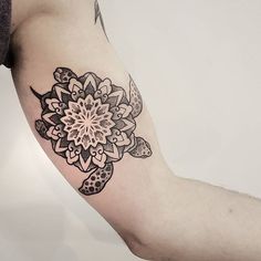 a black and white tattoo on the arm of a person with a flower in it