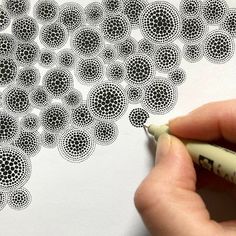 someone is drawing circles on paper with a marker