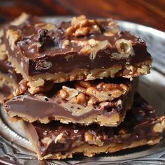 three pieces of chocolate and nuts are stacked on top of each other in a plate