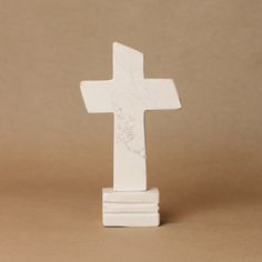 a white marble cross on a brown background