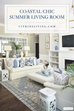 a living room with white furniture and blue accents