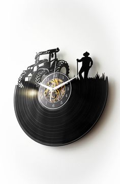 a clock made out of an old record with a farmer and tractor on the side