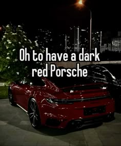 a red sports car parked in front of a building with the words oh to have a dark red porsche