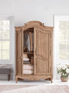 a wooden armoire sitting next to a window in a room with white walls and carpet