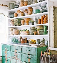 an old dresser with many pots and baskets on it's shelves in a room