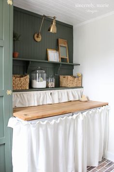 a kitchen with green cabinets and white curtains