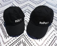 "Mama Heart and Mini Heart Hat. This listing is for TWO (2) Adjustable Dad Hat that says \"mama\" and \"mini\" with a heart in a cute font. Each set of 2 comes with one adult size dad hat, and one youth size dad hat. * Classic \"dad\" style hats * 100% bio-washed chino twill * Pre-curved visor * Unstructured, six-panel, low-profile * Adjustable buckle closure - antique brass * One adult hat and one youth hat * Youth size fits most kids and young adults Check out our policy page for return / exch Mommy Daughter Outfits, Baseball Caps, Dad Fashion, Cute Fonts, Sister Shirts, Mini Heart, Mommy And Me, Trucker Cap, Dad Hats