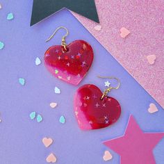 Product Specifications: 💖 Material: Craft resin 💖 Earring Size: Approx. 6 cm hanging 💖 Closure: Gold coloured hooks 💖 Colour: Red, pink 💖 Handmade 💖 Doming: Yes Handmade Heart Earrings For Valentine's Day Gift, Pink Heart Charm Earrings, Pink Heart-shaped Resin Jewelry, Red Heart Print Earrings For Gifts, Handmade Purple Earrings For Valentine's Day, Pink Heart-shaped Jewelry For Gift Making, Handmade Heart Drop Earrings For Valentine's Day, Handmade Heart Earrings For Valentine's Day Party, Trendy Handmade Heart Earrings For Valentine's Day