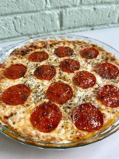 a pepperoni pizza sitting on top of a glass plate