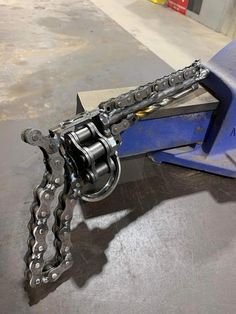 a close up of a metal object with chains on it's back end and two other objects in the background