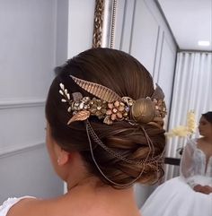 a woman in a wedding dress is looking at herself in the mirror while wearing a hair comb