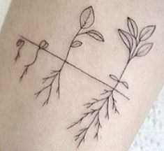 a tattoo on the leg of a woman with flowers and leaves drawn on it's side