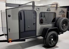 an off - road vehicle is parked in a garage with its doors open and lights on