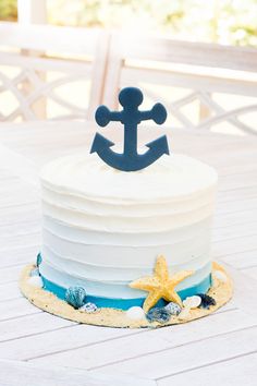 a blue and white cake with an anchor on top