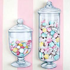 two glass jars filled with candy on top of a pink and white striped wall next to each other