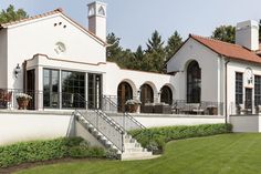 a large white house sitting on top of a lush green field