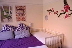 a bed room with a neatly made bed and paintings on the wall