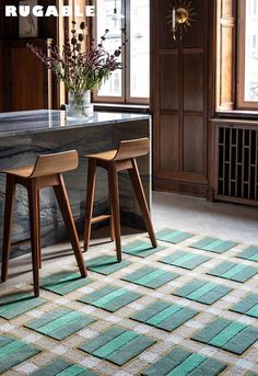 a kitchen area with two stools and a table