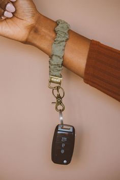 a person's hand holding a car keychain with a lanyard attached to it