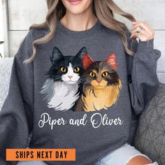 a woman wearing a sweatshirt with two cats on it and the words paper and glitter