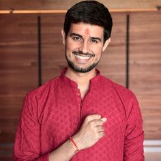 a man in a red shirt is smiling and posing for the camera with his hand on his chest