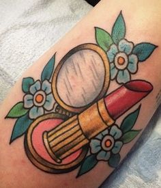 a tattoo with a magnifying glass and flowers on it