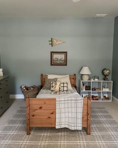 a bed room with a neatly made bed and dressers