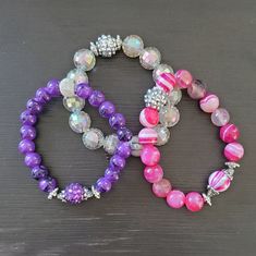 This set includes 1 pink, 1 purple, and 1 platinum colored elastic stretch bracelet. Trendy Pink Stretch Bracelet With Large Beads, Purple Stretch Bracelet With Large Round Beads, Adjustable Purple Faceted Beads Stretch Bracelet, Adjustable Purple Stretch Bracelet With Faceted Beads, Adjustable Purple Round Stretch Bracelet, Adjustable Pink Stretch Bracelet With Large Beads, Purple Stretch Bracelet With Colorful Beads, Purple Stretch Bracelet With Spacer Beads, Purple Stretch Bracelet With Spacer And Round Beads