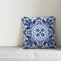 a blue and white pillow sitting on top of a couch