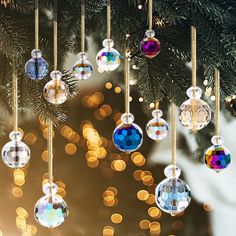 ornaments hanging from a christmas tree with lights in the background