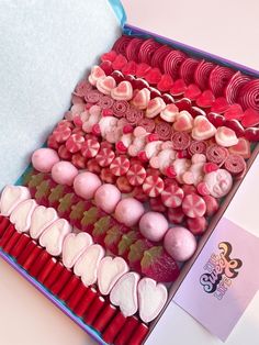 an open box filled with lots of different types of candies and hearts on top of each other