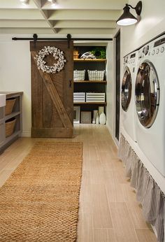 a washer and dryer in a laundry room next to a door with a wreath on it