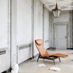 a chair sitting in the middle of a room next to a wall with white walls