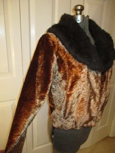 "Late 70's early 80's I think. 100% polyester. Dry clean. Soft textured velvet in dark or antique gold with a brown faux fur collar. Snap front closure. Front pockets. Marked size L. It measures 20\" long. 16 1/2\" across the back of the shoulders. 23 1/2\" sleeves. Laying flat seam to seam it's 21\" across under the arms. Very nice condition. The lining is pulled a little at the back shoulder blade seams (last photo). I ship same or next business day." Retro Fall Fur Coat With Faux Fur Lining, Retro Fur Coat With Faux Fur Lining For Fall, Retro Faux Fur Lined Coat For Fall, Retro Outerwear With Faux Fur Lining, Vintage Fur Coat With Faux Fur Lining For Fall, Retro Faux Fur Outerwear For Fall, Retro Brown Fur Coat For Fall, Fitted Retro Fur Coat For Fall, Retro Brown Faux Fur Coat